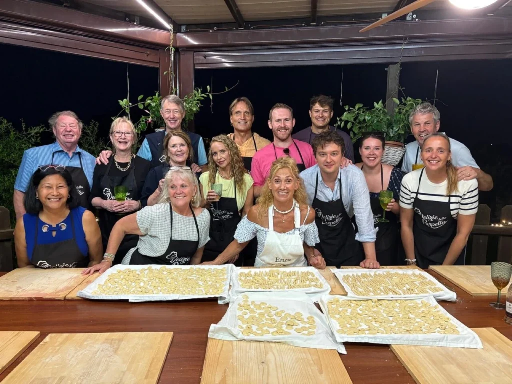Guests smiling around the table with fresh pasta