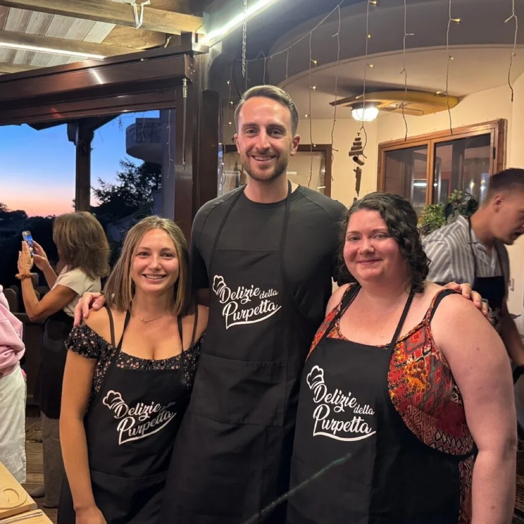 Guests smiling around the table with fresh pasta