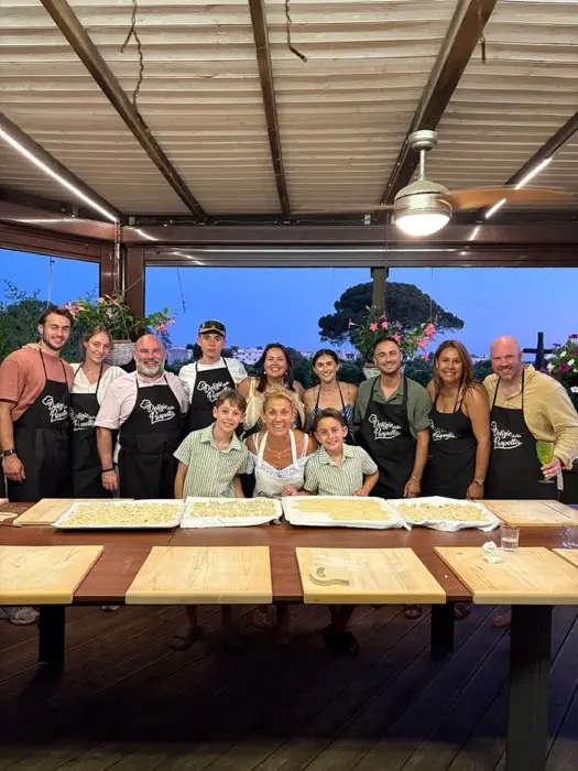 Guests smiling around the table with fresh pasta